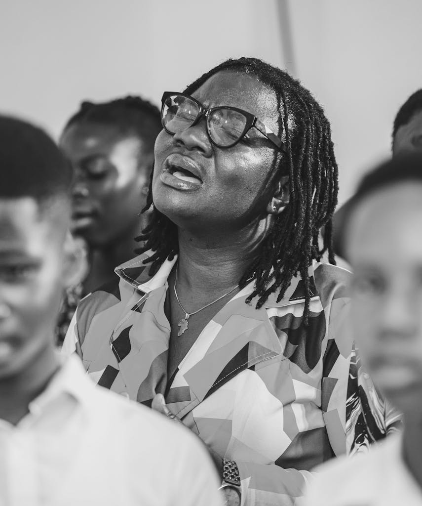 Black and White Candid Photo of a Woman Singing in a Crowd
